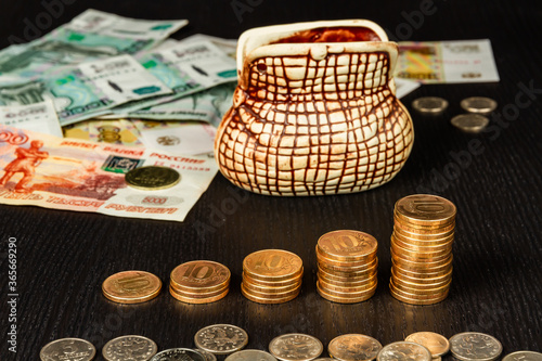 piggi bank and russian money coins and paper rubles lying on the table photo