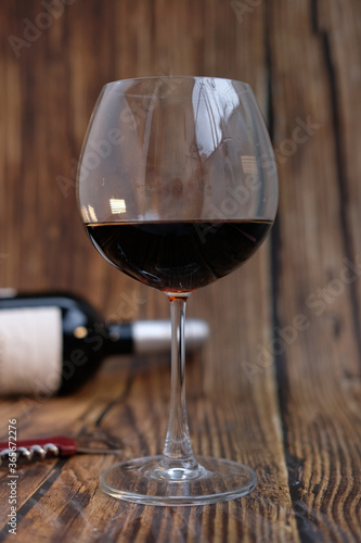 Red wine glasses and bottle on wooden table background, space for text