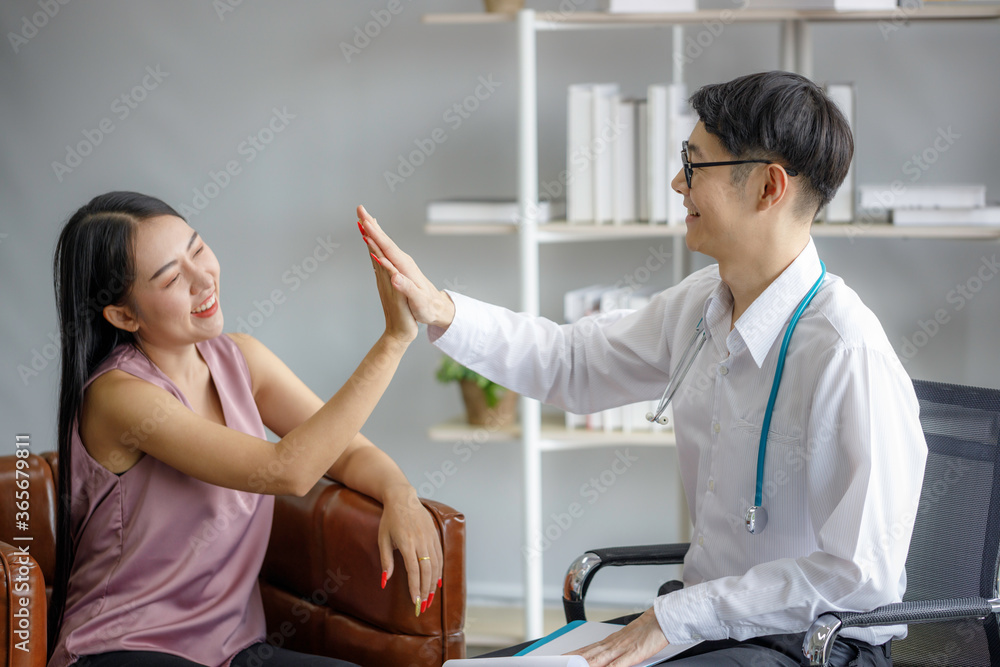 Obraz premium Friendly Asian male doctorcoordinate hands female patient and they smiled at each other. Medical psychology in encouraging and reducing the negative effects of sick people.