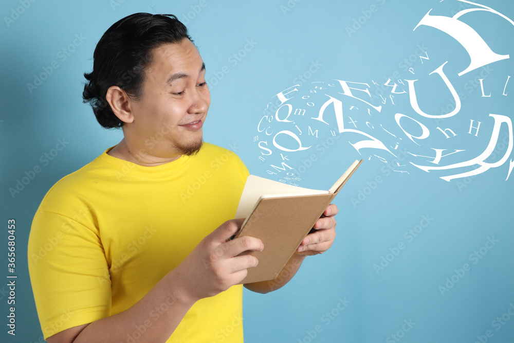Happy Man Smiling While Reading Book Happy Man Smiling While Reading Book