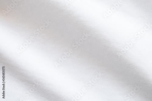 Top view close up shot of white fabric cotton shirt with woven gradient detail. Background and wallpaper concept.