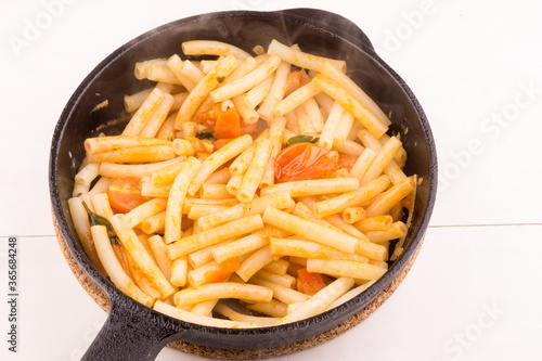 Fast and easy italian pasta arrabiata in a frying pan, close-up