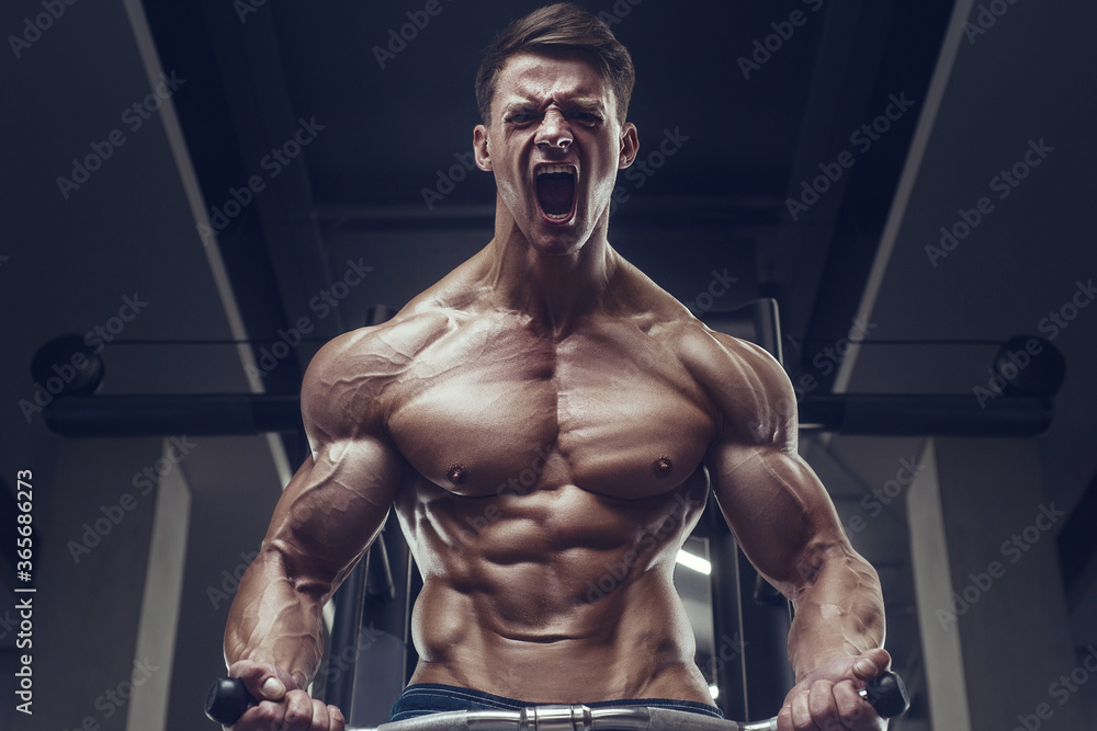 Bodybuilder strong man pumping up biceps muscles Bodybuilder strong man pumping up biceps muscles