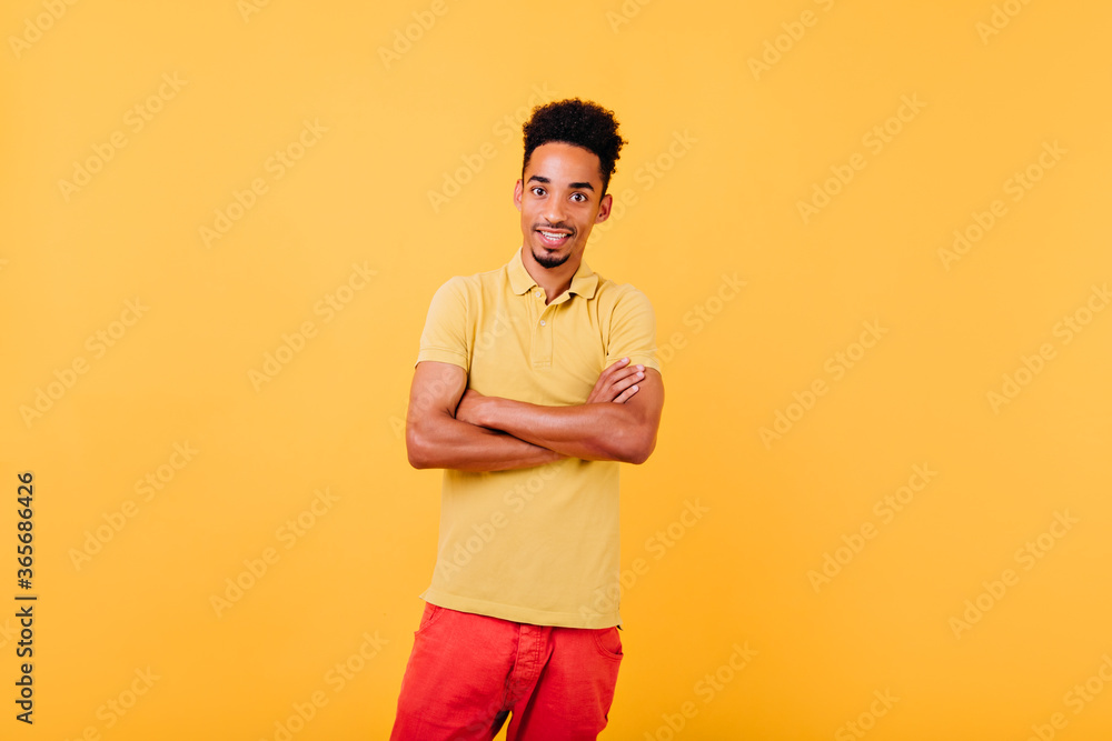 Surprised well-dressed african model posing with arms crossed. Indoor shot of amazed man standing in confident pose. Surprised well-dressed african model posing with arms crossed. Indoor shot of amazed man standing in confident pose.