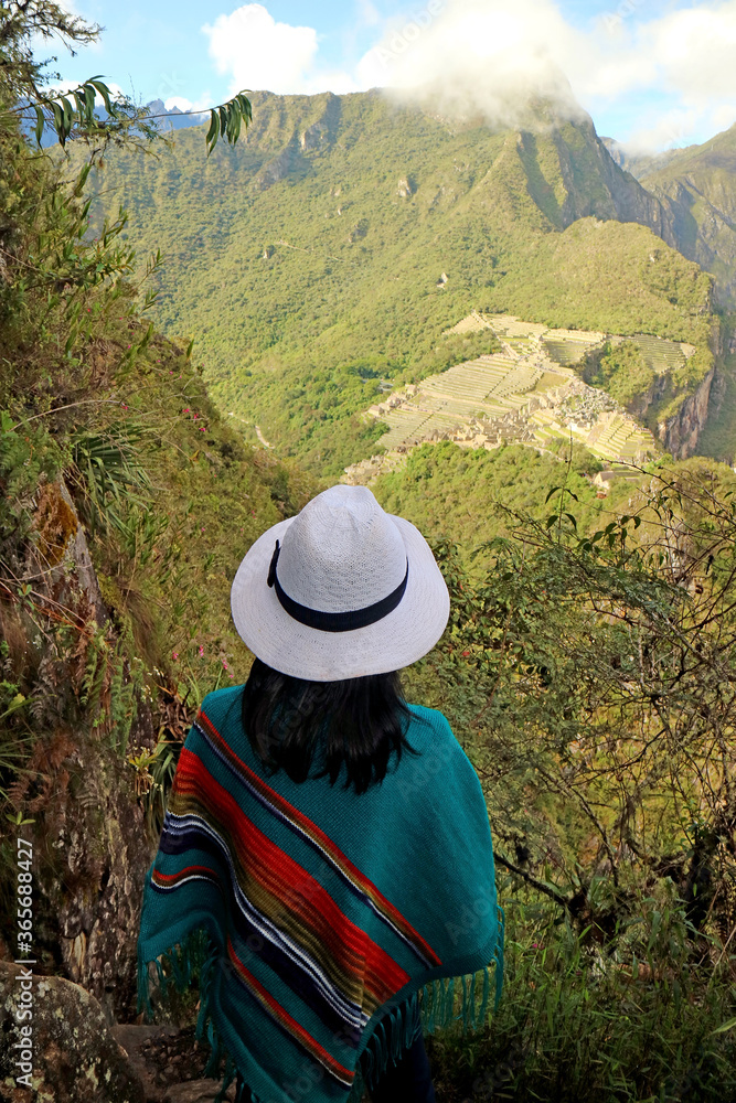 Female traveler impressed by the amazing aerial view of the Inca citadel ruins of Machu Picchu view from Huayna Picchu mountain, Cuzco, Peru Female traveler impressed by the amazing aerial view of the Inca citadel ruins of Machu Picchu view from Huayna Picchu mountain, Cuzco, Peru