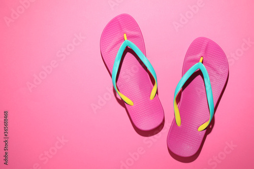 Pair of stylish flip flops on pink background, top view with space for text. Beach objects