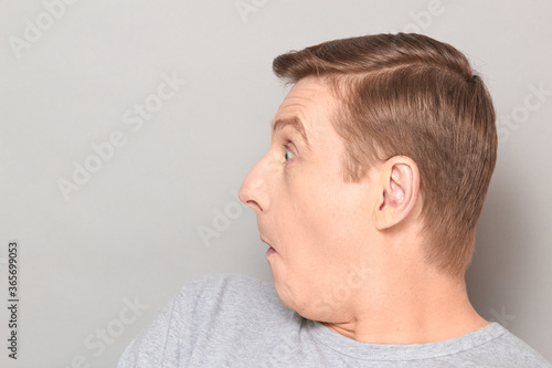 Portrait of funny surprised man, looking at something extraordinary