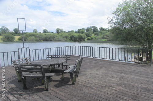 Old lakeside furniture and decking with lake view © liam