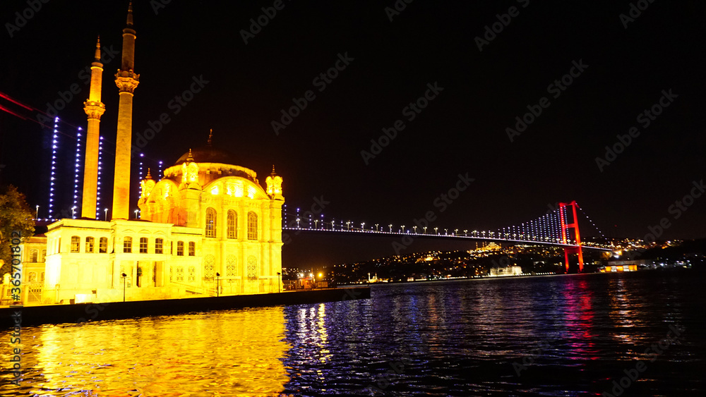 The Great Mecidiye Mosque and Bosphorus bridge in Istanbul at night, black sky and sea 