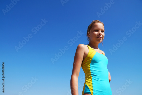 girl in a swimsuit against a clear blue sky