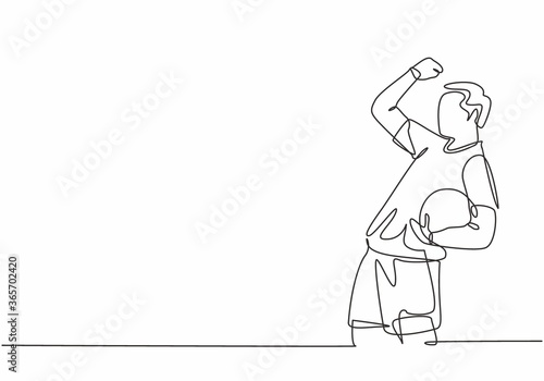 One continuous line drawing of young soccer player celebrating goal keeping ball on his hand and punching fist to the sky. Goal scoring celebration concept single line draw design vector illustration