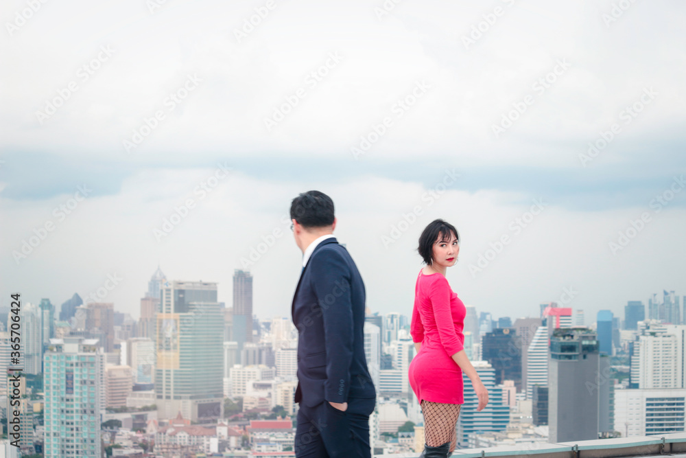 Businessman in suit and attractive woman in red dress walking on street in opposite direction with skyscraper city view, looking and have a crush on each other Businessman in suit and attractive woman in red dress walking on street in opposite direction with skyscraper city view, looking and have a crush on each other