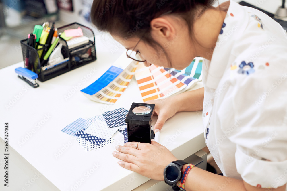 Female fashion designer holding color samples choosing fabric textile at workplace, dressmaker or tailor checking fabric quality, close up view Female fashion designer holding color samples choosing fabric textile at workplace, dressmaker or tailor checking fabric quality, close up view