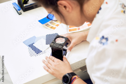 Female fashion designer holding color samples choosing fabric textile at workplace, dressmaker or tailor checking fabric quality, close up view   