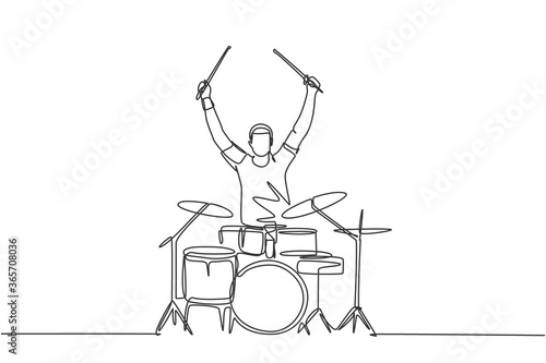 Valokuva One single line drawing of young happy male drummer raise drumstick up while play drum set on music concert stage