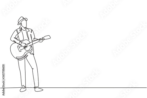 One continuous line drawing of young happy male guitarist wearing hat and playing acoustic guitar on street road. Trendy musician artist performance concept single line draw design vector illustration