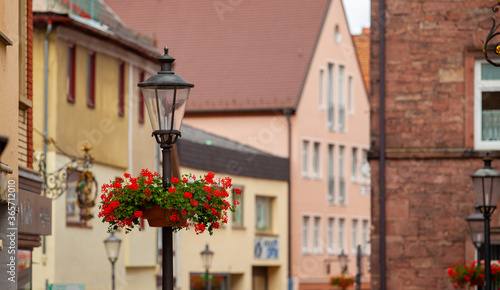Fototapeta Naklejka Na Ścianę i Meble -  Street lamp with flowers and a street in the background.