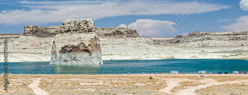 Scenic view of Lone Rock Beach with camping vehicles at Lake Powell in the desert in the United States