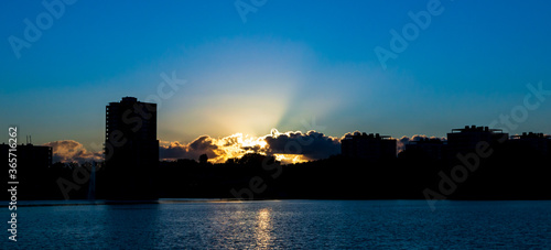 Silhouettes of appartment buildings near a lake at sunset. photo