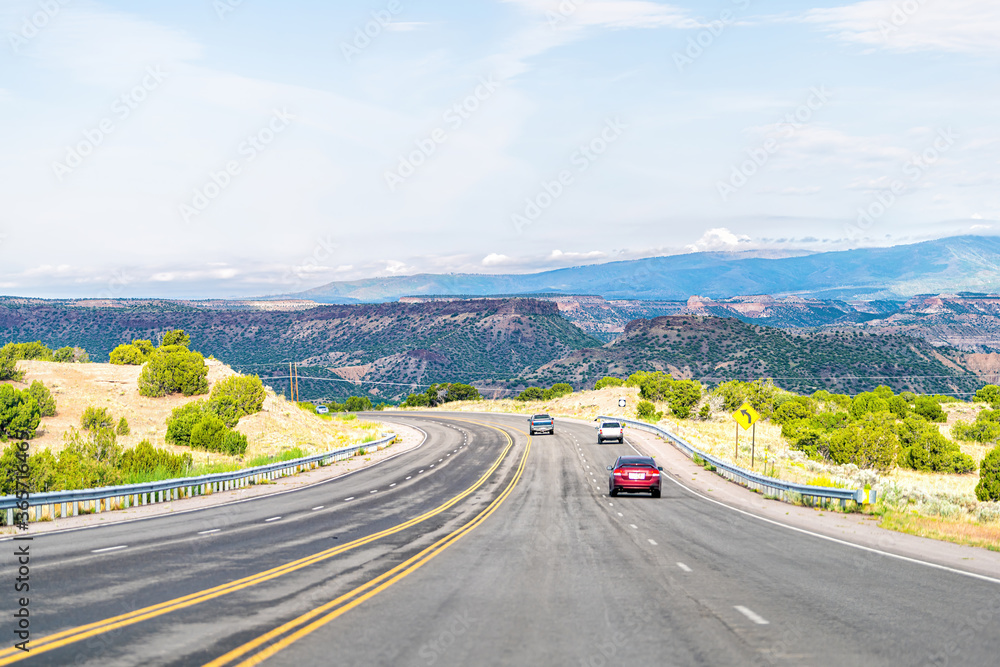 Fototapeta premium Hrabstwo Santa Fe na pustyni w Nowym Meksyku z samochodami jadącymi autostradą do Los Alamos jadącymi ulicą 502 na zachód
