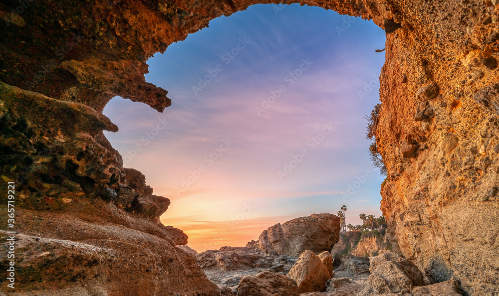 A natural arch at a Southern California beach during a sunset