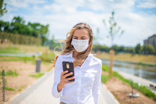 Masked woman using her mobile phone