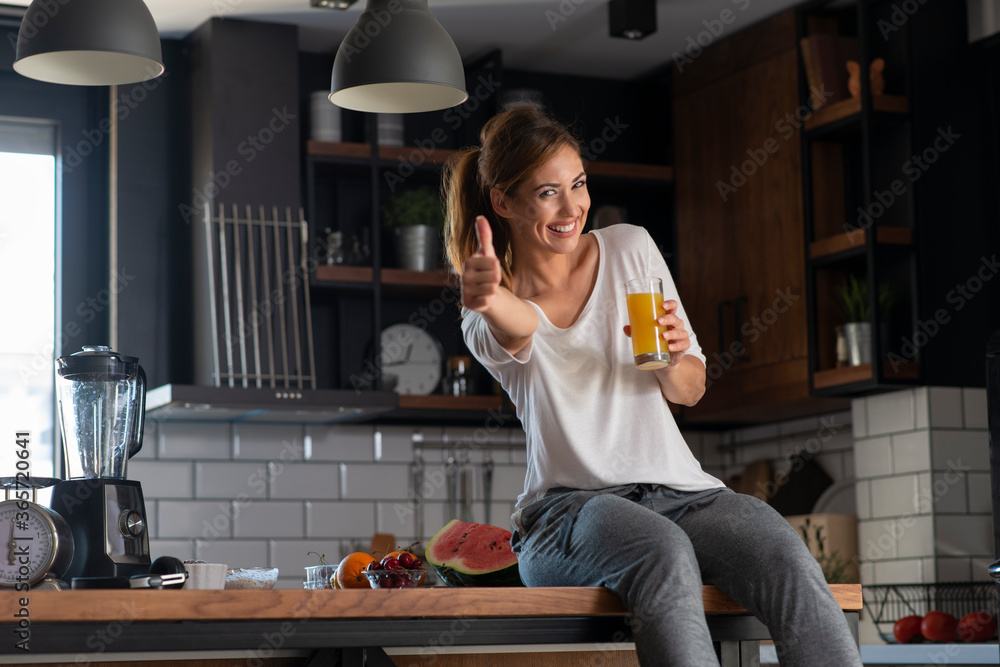 Portrait of a beautiful women holding glass with tasty juice indoors - obrazy, fototapety, plakaty 