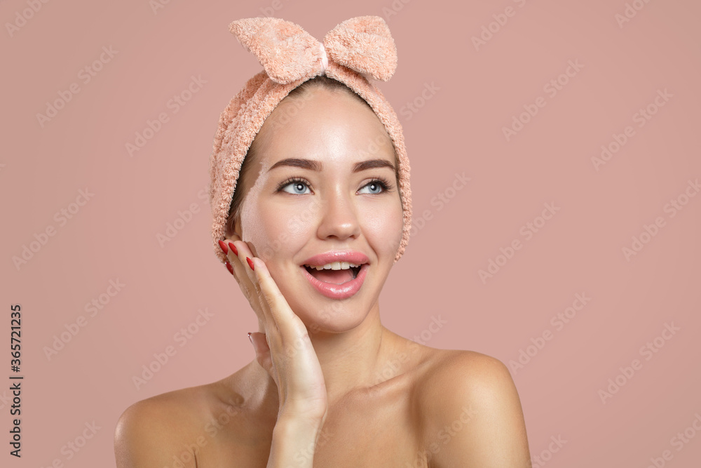The bright young woman shows surprise. Open mouth and smile. Hand on her face. Clean skin The bright young woman shows surprise. Open mouth and smile. Hand on her face. Clean skin