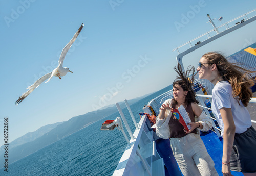 Young girls feeding seagulls on a ship