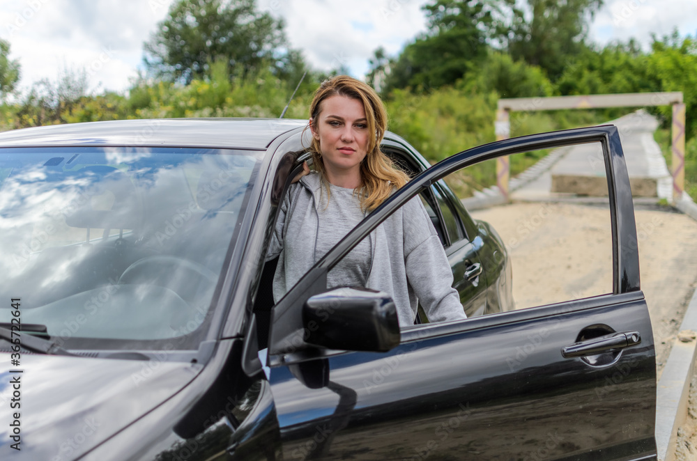 Young charming girl driving a black car Young charming girl driving a black car