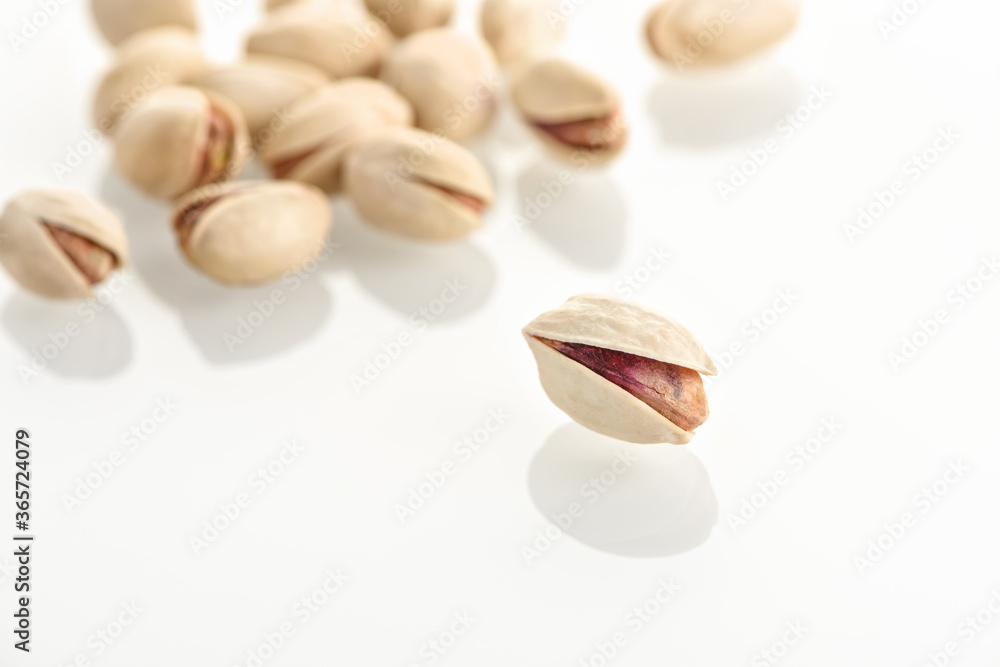 Pistachios on a white glass surface.