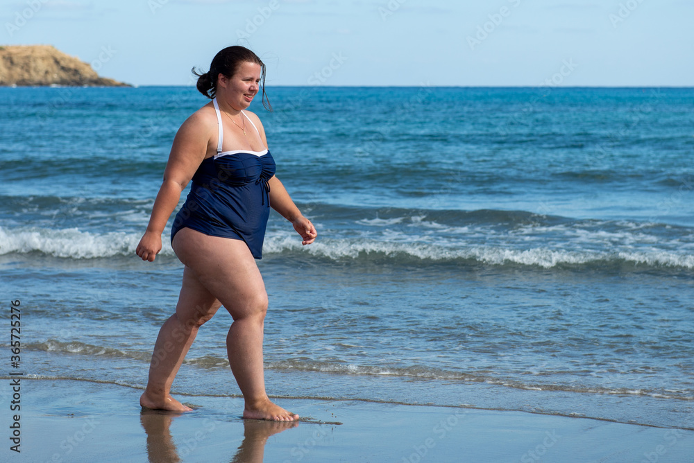 Body positive. Happy plump woman on the beach. 