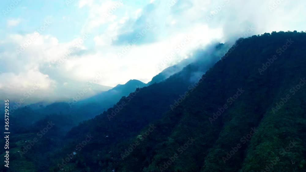 Clouds above green mountains in eastern tropics. Bali, Indonesia. Drone aerial, slow motion. Clouds above green mountains in eastern tropics. Bali, Indonesia. Drone aerial, slow motion.