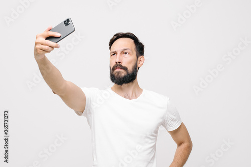 young man makes selfies.Isolated on light background