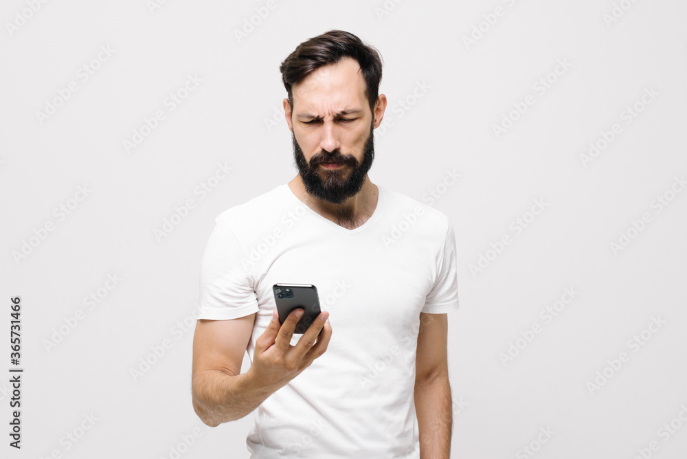 Pensive young man is using a mobile phone. Pensive young man is using a mobile phone.