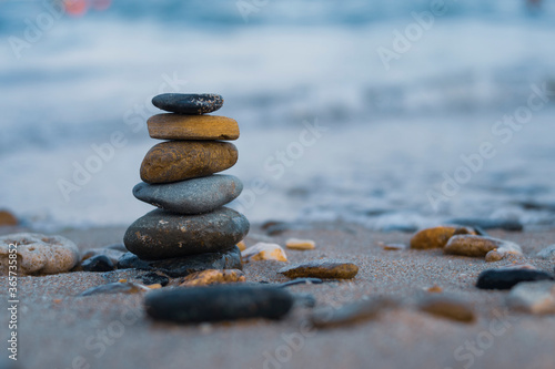 Pebbles are piled on a volcanic rock by the sea. Zen concept. Copy space