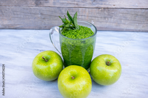 Healthy smoothie with three apples around it