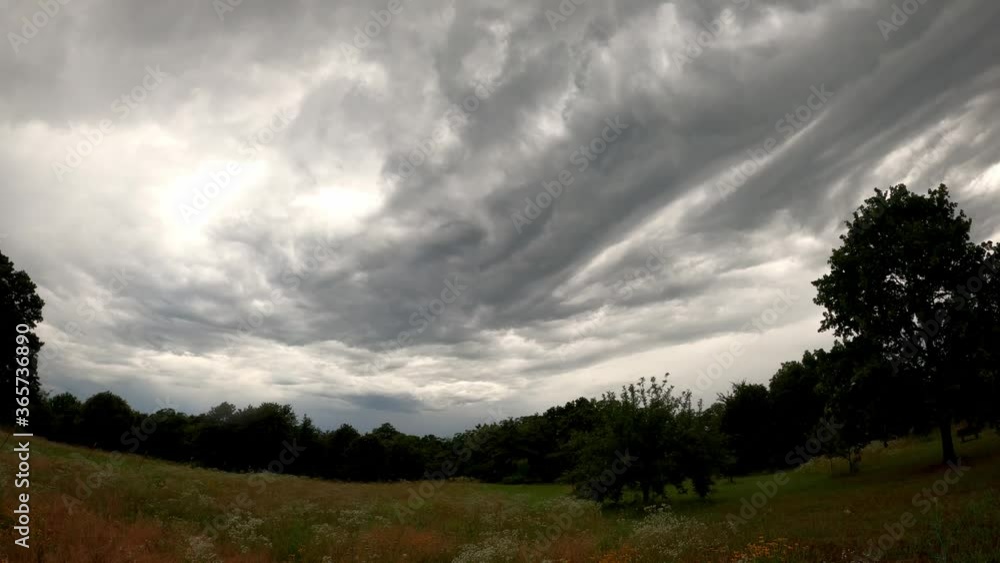 Wide angle time lapse of turbulent rain clouds approaching over a rural meadow Wide angle time lapse of turbulent rain clouds approaching over a rural meadow