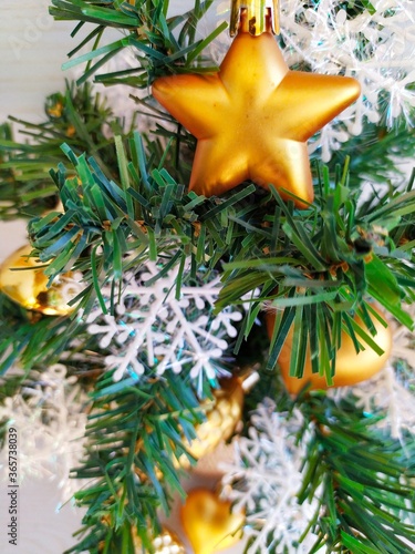 Small christmas tree with golden toys and snowflakes