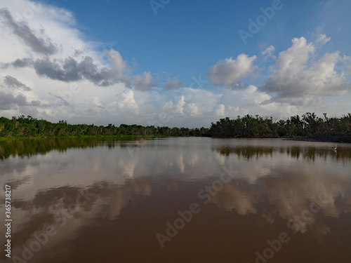 Summer cloudscape reflected in calm water of Eco Pond in Everglades National Park, Florida.