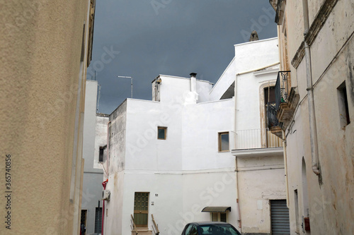 Backlit pastel buildngs under a stormy sky photo