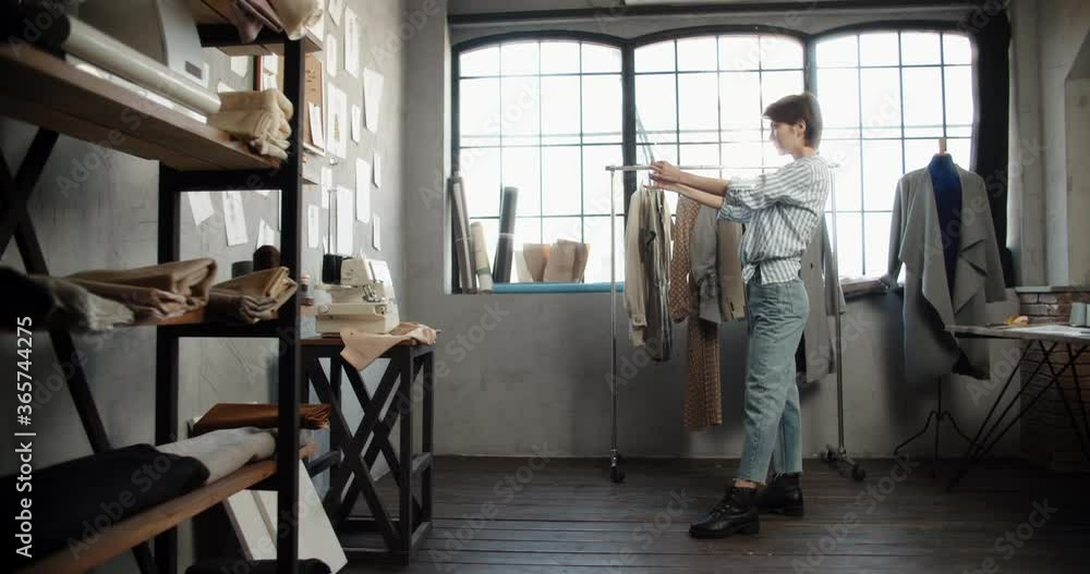 Authentic asian clothes designer is working at her office, looking at sketches pinned to wall, designing her new collection - small business, fashion concept 4k footage Authentic asian clothes designer is working at her office, looking at sketches pinned to wall, designing her new collection - small business, fashion concept 4k footage