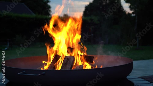 Iron fire pit and burning fire in a garden .  Campfire ,  close up image .