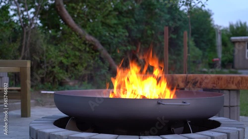 Iron fire pit and burning fire in a garden .  Campfire ,  close up image .