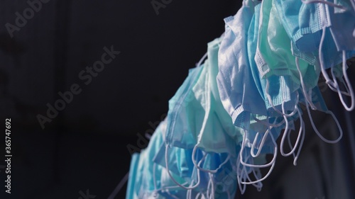 Hanging disposable masks hanging outside for disinfection and sterilization. Concept of new normal, mandatory face masks bylaw in public indoor settings. Reuse, shortage and price gouging concept. COV photo