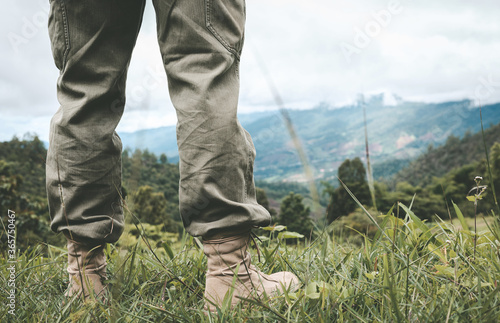 Close-up of male hiker shoes standing on a mountain trail.