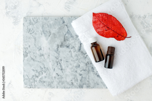 Autumn falll Seasonal Spa set Massage essential oils, towels on gray marble plate, organic cosmetic products, aromatherapy and alternative medicine concept, spa salon banner, flyer, coupon photo