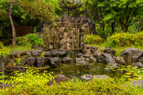Stone pond fountain on rainy day.