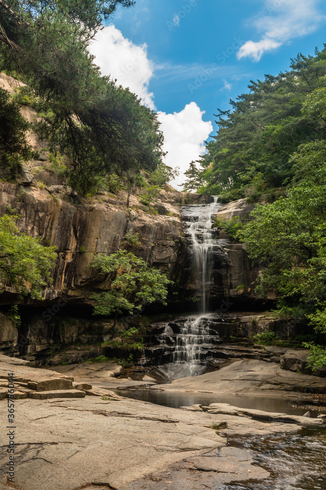 Waterfall cascading down rocky mountainside.