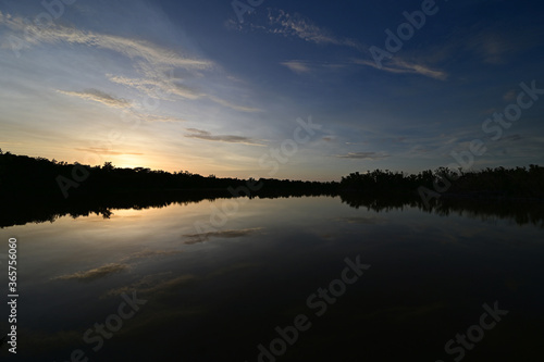 Brilliant colorful clouds in twilight reflected on calm water of Eco Pond in Everglades National Park, Florida on summer evening. © Francisco